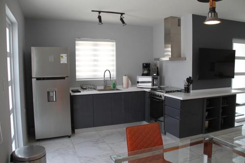 una cucina con elettrodomestici bianchi e neri e una sedia arancione di Xevize Apartment 4 a Palm Beach