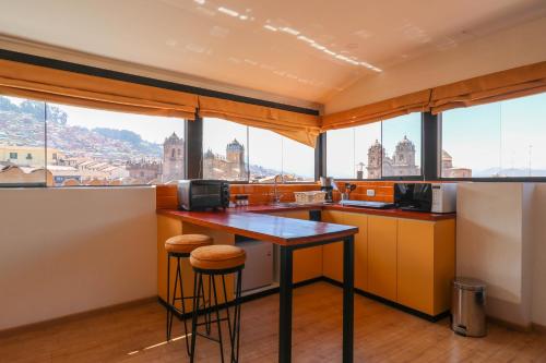 a kitchen with a counter with a view of the city at Muru Suites near Plaza de Armas Cusco by Wynwood House in Cusco