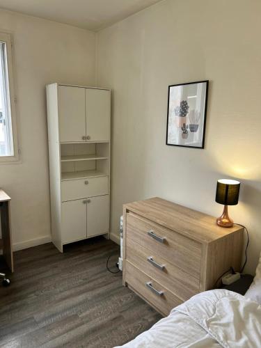 a bedroom with a dresser and a bed and a cabinet at Private Room in a Shared Appartment in Asnières-sur-Seine