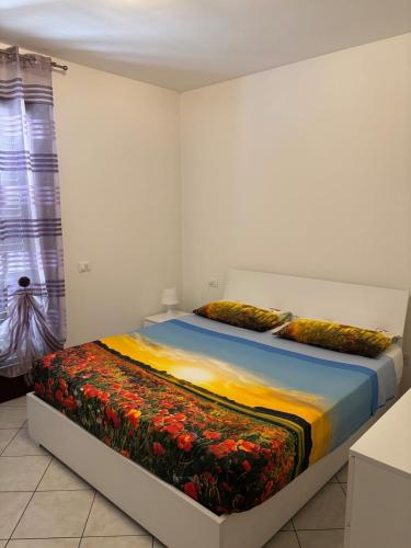 a bedroom with a bed with a colorful blanket at Home 14 in Tortoreto Lido