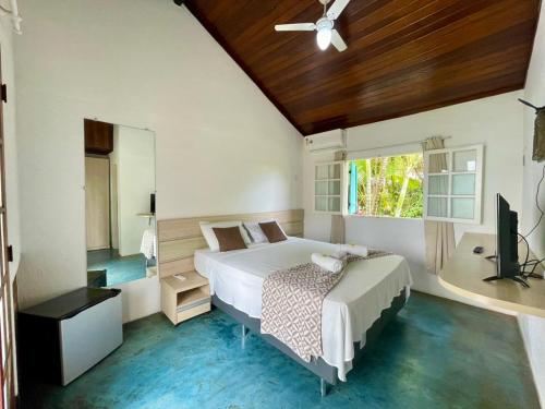 a bedroom with a bed and a television in it at Atobá Villas in Paraty