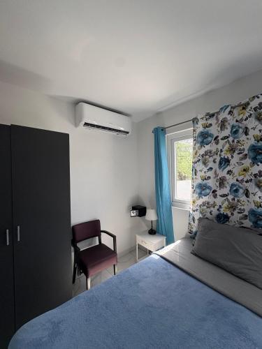 a bedroom with a bed and a chair and a window at Viva Alto Vista! in Noord