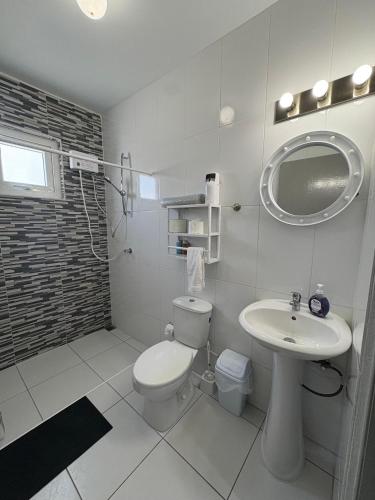 a white bathroom with a toilet and a sink at Viva Alto Vista! in Noord