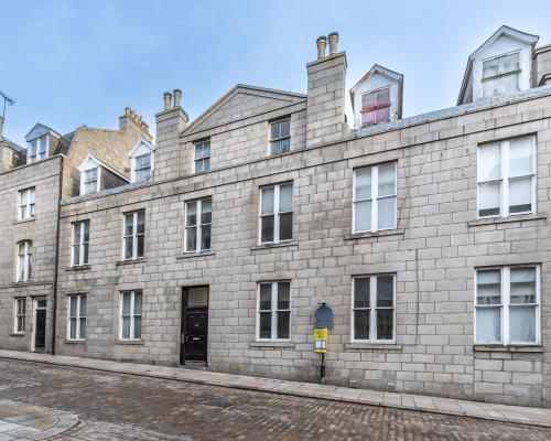 a large brick building on a street at jaysapartment III in Aberdeen