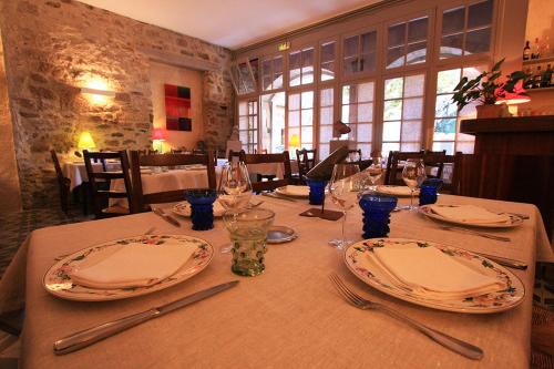 a table with plates and utensils on top of it at Hôtel d'Alibert in Caunes-Minervois