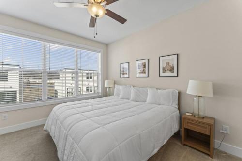 a bedroom with a bed with a ceiling fan and a window at Riverview Retreat: Neyland Stadium – sleeps 8! in Knoxville