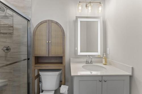 a bathroom with a sink and a toilet and a mirror at Riverview Retreat: Neyland Stadium – sleeps 8! in Knoxville