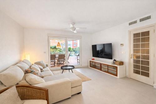 a living room with a couch and a flat screen tv at Apartamento Olimpic Beach in Roquetas de Mar