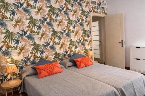 a bedroom with a bed with orange pillows at Apartamento Olimpic Beach in Roquetas de Mar