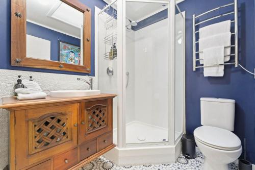 a bathroom with a shower and a toilet and a sink at Chic Converted Barn in Matakana with Spa in Big Omaha