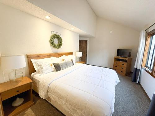 a bedroom with a large white bed and a television at Sunbeam Shores 3Bed 3 Bath Pool-6PP in Osage Beach