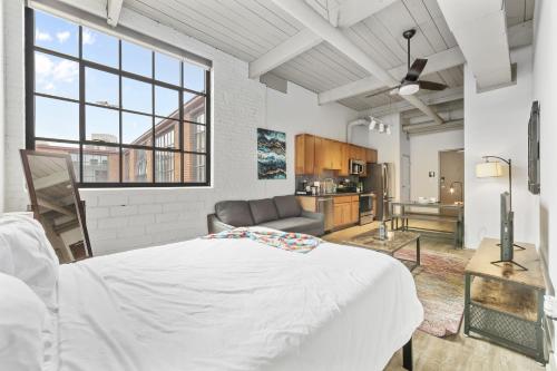 a bedroom with a large white bed and a kitchen at 2125 Superior Living in Cleveland