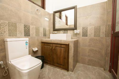 a bathroom with a toilet and a sink and a mirror at Meadow Villa - Ella in Ella