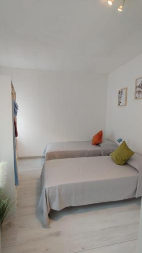 a bedroom with two beds and a white wall at Levico Nature Escape in Levico Terme