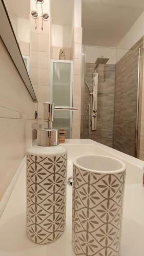 a bathroom with a white counter top with two trash at Levico Nature Escape in Levico Terme