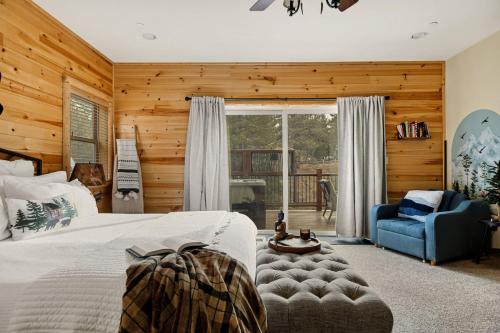 a bedroom with a bed and a blue chair at Bear Creek Lodge with Hot Tub in Big Bear Lake