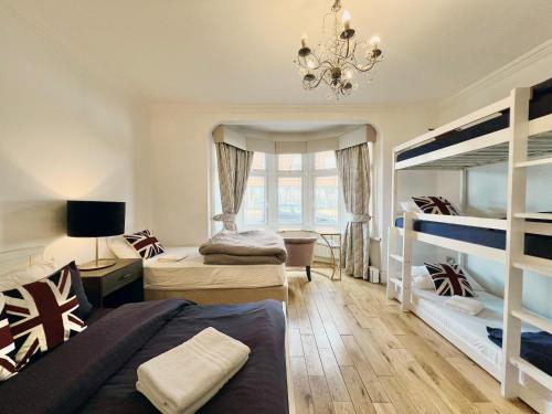 a bedroom with two bunk beds and a chandelier at Gants Hill House in Redbridge