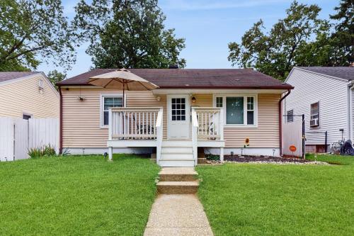 a small house with a porch with an umbrella at 2 Mi to Beach! Hot Tub Haven in Michigan City in Pottawattamie Park