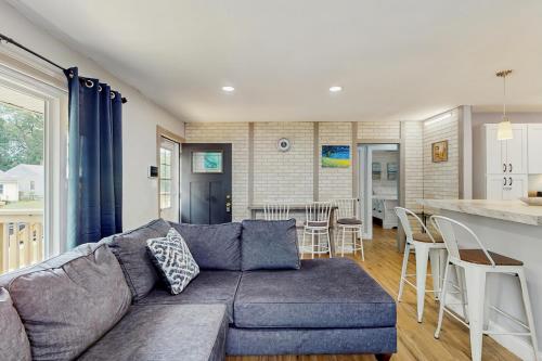 a living room with a couch and a kitchen at 2 Mi to Beach! Hot Tub Haven in Michigan City in Pottawattamie Park