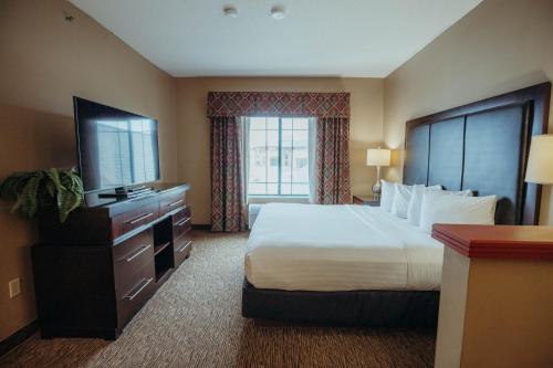 a hotel room with a bed and a television at Wildwood Lodge in Pewaukee