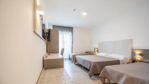 a hotel room with two beds and a window at Nuovo Hotel SettiBi in Giulianova
