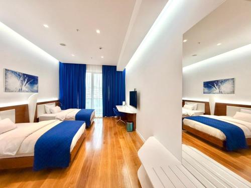a bedroom with two beds and a desk at Condo Studio Plaza in Budva