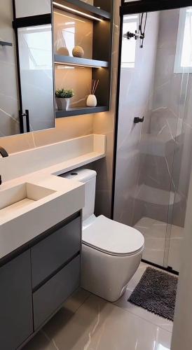 a bathroom with a toilet and a sink and a shower at Flat Cerejeiras - Condomínio Privado in Bananeiras