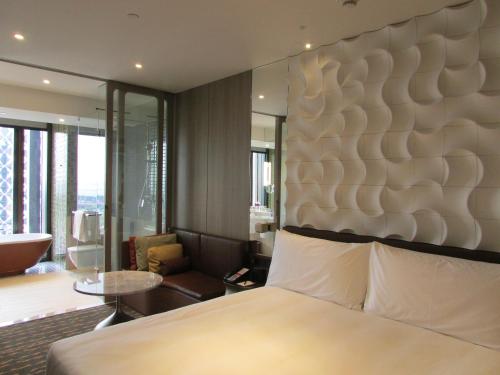 a bedroom with a large bed and a living room at Crowne Plaza Changi Airport by IHG in Singapore