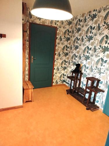 a room with a green door and two wooden chairs at CHEZ CELINE en campagne in Mazerny