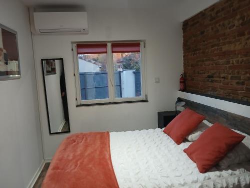 a bedroom with a large white bed with red pillows at Gite de PHAM in Belberaud