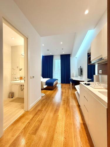 a kitchen and living room with wood floors and a room at Condo Studio Plaza in Budva