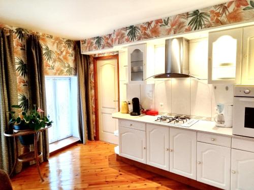 a kitchen with white cabinets and a stove top oven at CHEZ CELINE en campagne in Mazerny