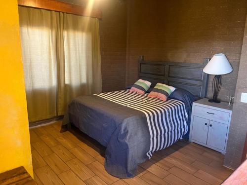 a bedroom with a bed with two pillows and a lamp at Luxurious Cabin Retreat in Tapalpa 4 Bedrooms 6 Bathrooms in Tapalpa