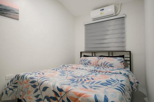 a bedroom with a bed with a comforter at Joanna Transient Home in Palestina