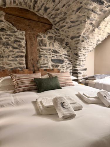 a large white bed with towels on top of it at Granuit Alpine Home in Sauze di Cesana