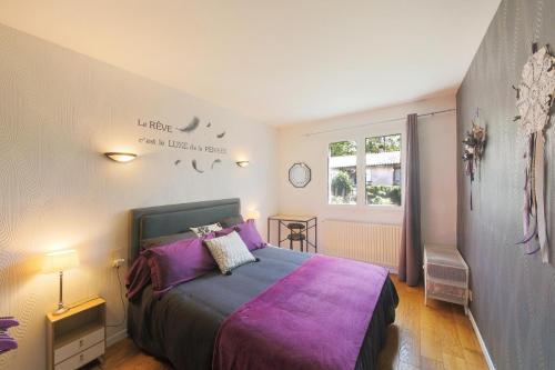a bedroom with a bed with purple sheets and a window at Gite la Provençale in Albi