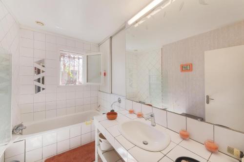 a bathroom with a sink and a mirror and a tub at Gite la Provençale in Albi