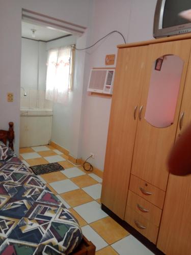 a bedroom with a cabinet and a tiled floor at Felipenas Lodging House in Matalom