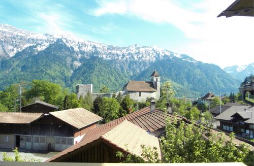 a view of a village with mountains in the background at Royal Swiss Apartments in Ringgenberg