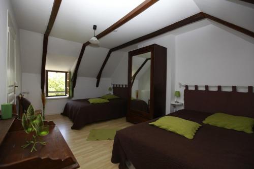 a bedroom with two beds and a mirror at Gite linstant rêvé in Labesserette
