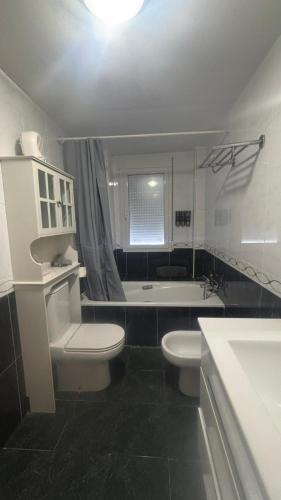 a bathroom with a toilet and a sink and a tub at ElFogaril in Teruel