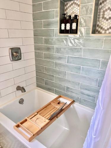 a bath tub with a wooden tray on top of it at HPThe Bungalow Spectrum Bojangles Fenced Yard Dog in Charlotte