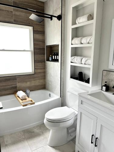 a bathroom with a toilet and a tub and a sink at HPThe Abode Downtown Bojangles Dogs Welcome Yard in Charlotte