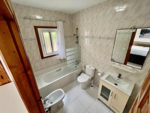 a bathroom with a toilet and a sink and a tub at Chalet con piscina y vistas en Urb Marcolina, Alcocéber in Alcossebre