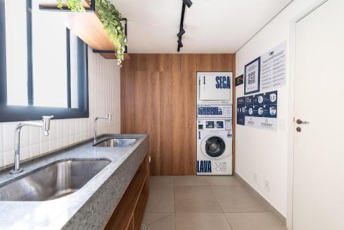 a bathroom with a sink and a washing machine at Studio with Pool and Gym - DP203 in São Paulo