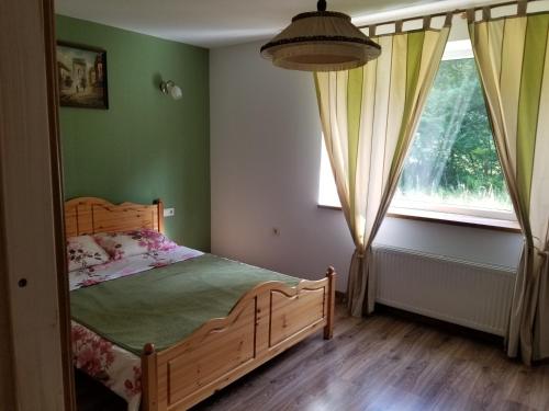 a bedroom with a wooden bed and a window at A&S Vidugiris in Jurbarkas