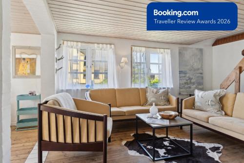 a living room with two couches and a table at The Cozy Cottage in Hirtshals