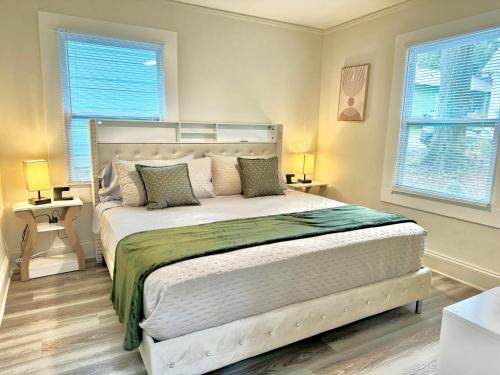 a bedroom with a large white bed with two windows at HPThe Haus BOFA Stadium Spectrum Bojangles Dogs in Charlotte
