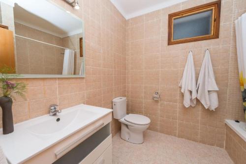 a bathroom with a toilet and a sink and a mirror at Villa Canescandeu in Port de Pollensa