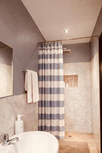 a bathroom with a shower curtain and a sink at Nadi Airport Bed & Breakfast in Nadi